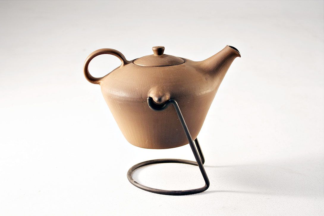 Foto Ceramic Teapot on Metal Stand