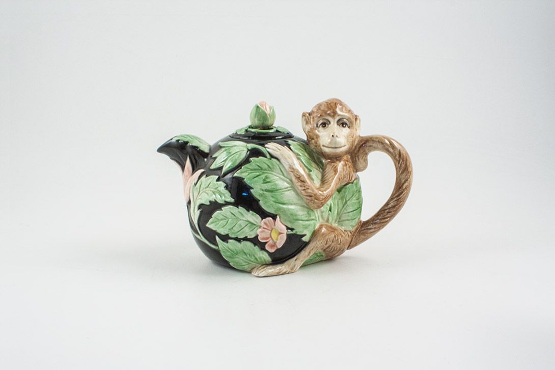 Foto Black Teapot With Flower Pattern And Monkey Handle