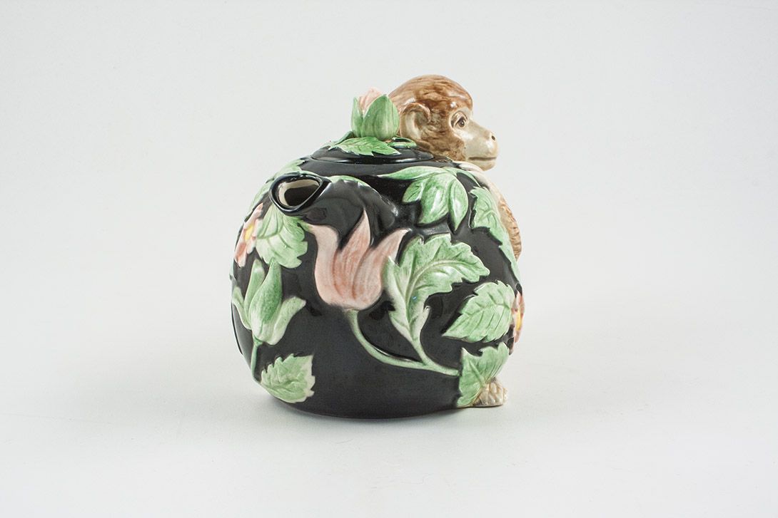 Foto Black Teapot With Flower Pattern And Monkey Handle